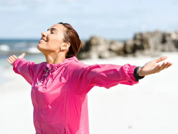 Sportieve vrouw in sportkleding staande aan de kust — Stockfoto