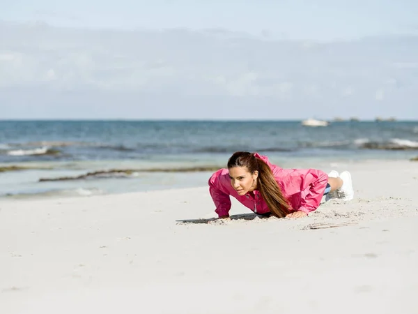 Mujer joven en la playa haciendo ejercicios Imagen de archivo