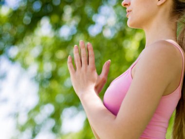 Parkta yoga yapan genç kadın.