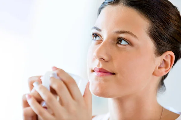 Happy young woman with cup of tea or coffee at home — Stock Photo, Image