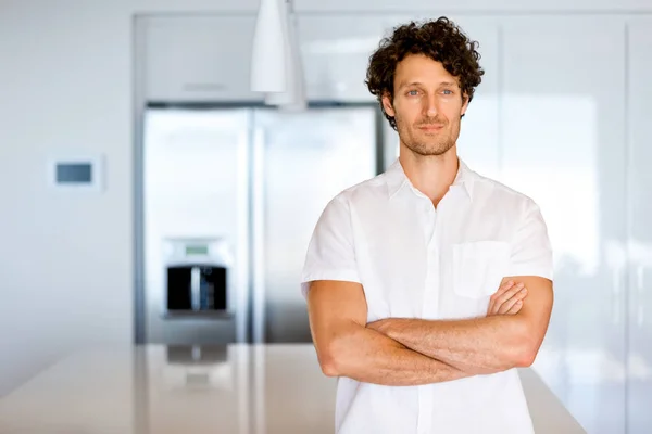 Portrait d'un jeune homme intelligent debout dans la cuisine — Photo