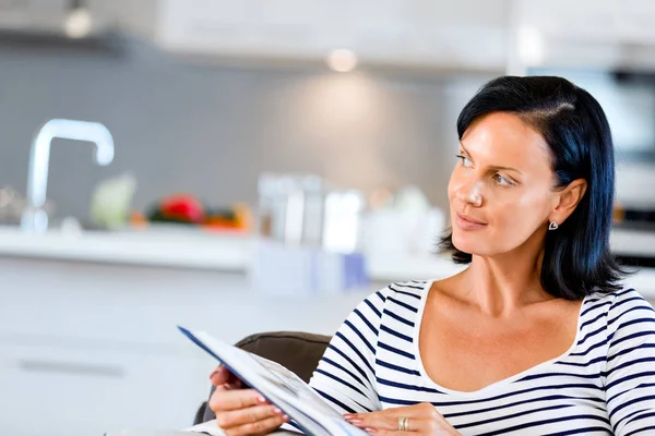 행복 한 여자는 소파에 앉아 책을 읽고 — 스톡 사진