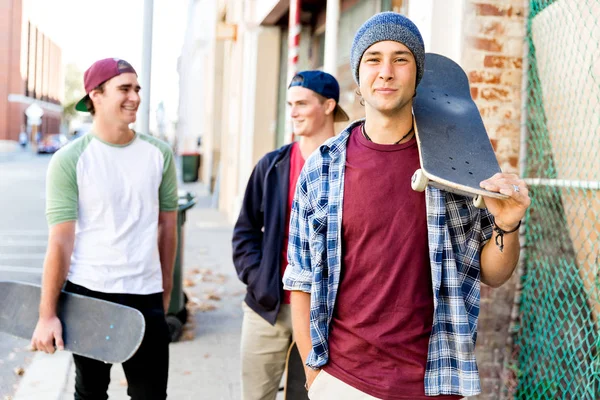 Dospívající chlapec kráčí na ulici s jeho skateboard — Stock fotografie