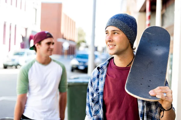 Amigos adolescentes caminando por la calle con patinetas — Foto de Stock