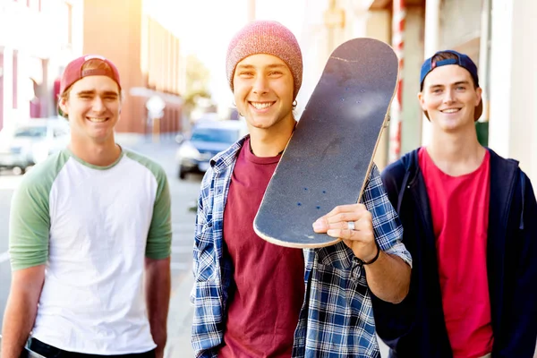 Teenage friends walking at the street with skateboards — Stock Photo, Image