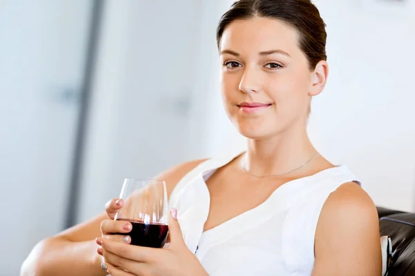 Hermosa mujer joven sosteniendo copa con vino tinto — Foto de Stock