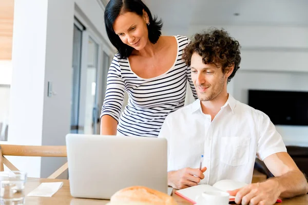 Felice coppia moderna che lavora sul computer portatile a casa — Foto Stock