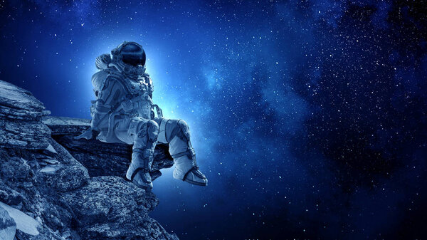 Astronaut sitting on cliff edge against dark starry sky. Mixed media