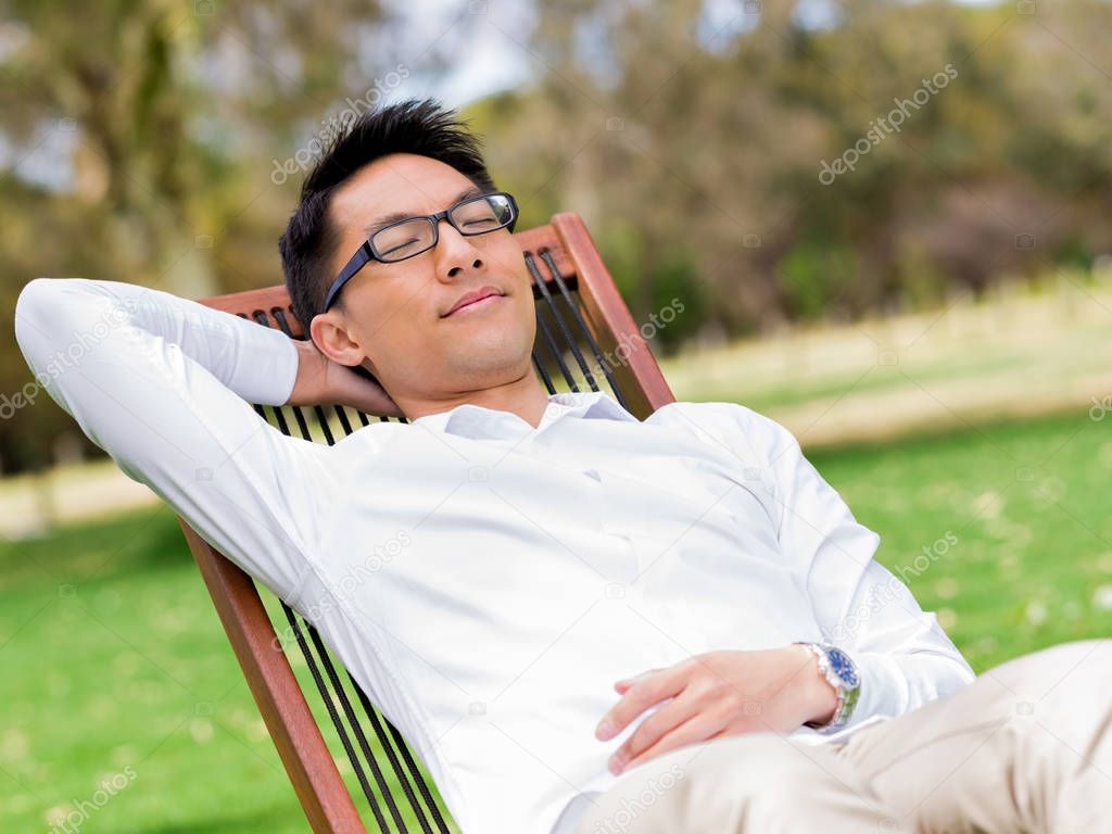 Young businessman relaxing during his break in park