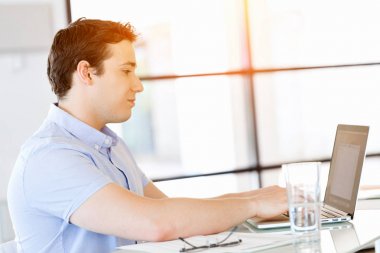 Bilgisayarda çalışan yakışıklı işadamı