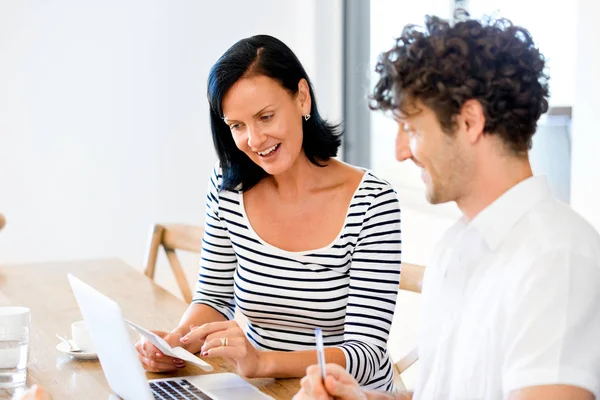 Gelukkige moderne paar bezig met laptop thuis — Stockfoto