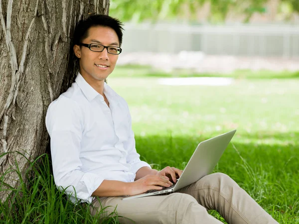 Νεαρός επιχειρηματίας χρησιμοποιώντας φορητό υπολογιστή ενώ κάθεται σε εξωτερικούς χώρους — Φωτογραφία Αρχείου