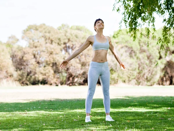 Ung kvinna motionerar i parken — Stockfoto