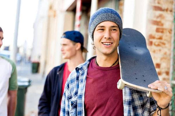 Dospívající chlapec kráčí na ulici s jeho skateboard — Stock fotografie