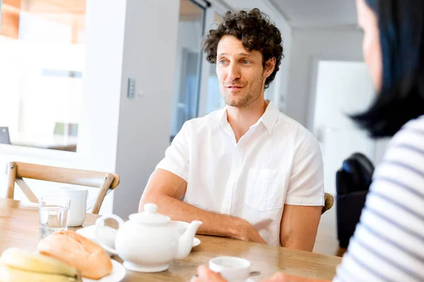 Portrait of man sitting and talking to woman indoors — Stock Photo, Image