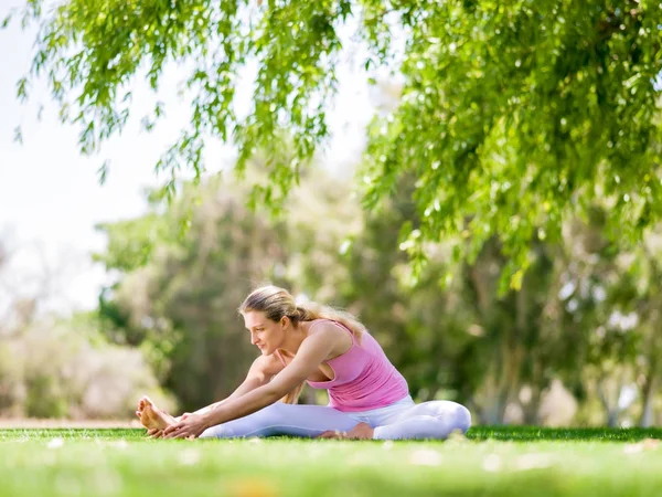 Jeune femme faisant du yoga dans le parc — Photo