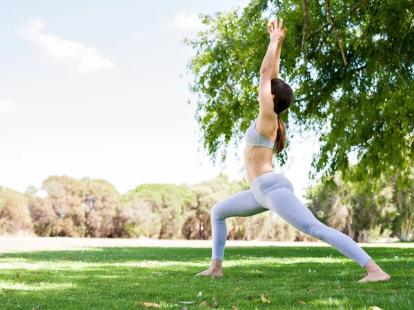 Genç kadın parkta yoga yapıyor. — Stok fotoğraf