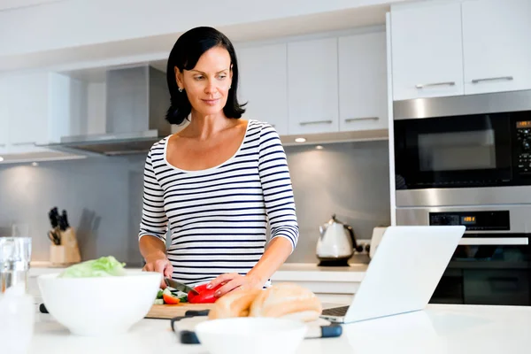 Mulher bonita de pé na cozinha e cozinhar — Fotografia de Stock