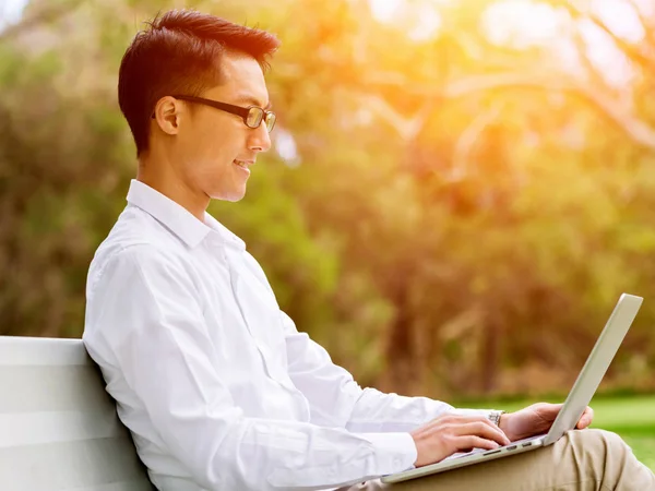 Fiatal üzletember használ laptop ülve a szabadban — Stock Fotó