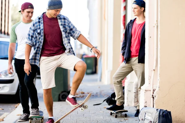 Amis adolescents marchant dans la rue avec des planches à roulettes — Photo