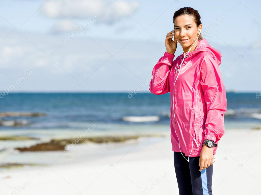 Sporty woman with earphones on the sea coast