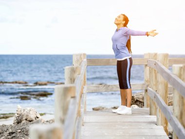Atletik kadın spor giyim daimi deniz kenarında