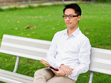 Not Defteri ile bankta oturmuş çekici düşünceli işadamı