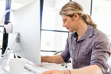 Bilgisayarda çalışan yakışıklı işadamı