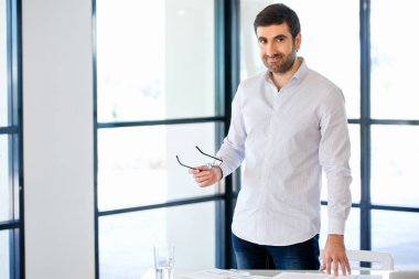 Ofiste duran genç beyaz iş adamı