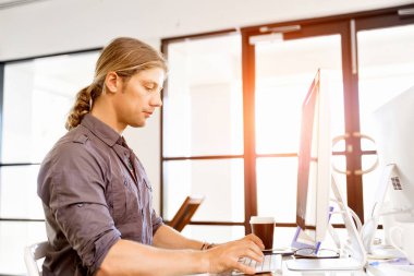 Bilgisayarda çalışan yakışıklı işadamı