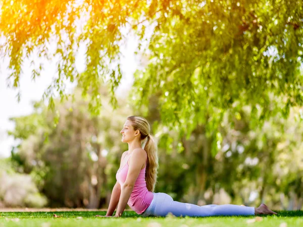 Młoda kobieta uprawia jogę w parku — Zdjęcie stockowe