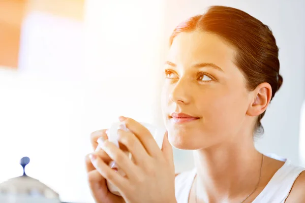 Joyeux jeune femme avec une tasse de thé ou de café à la maison — Photo