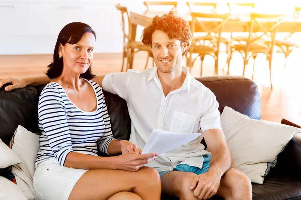 Couple with papers in their living room — Stock Photo, Image