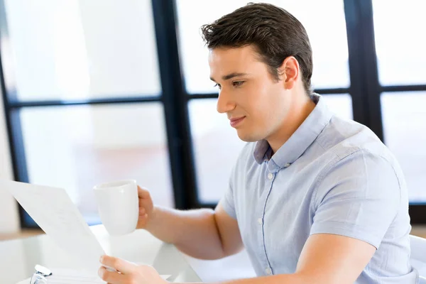 Young businessman in office with a mug — Stock Photo, Image