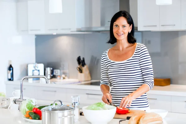 Mulher bonita de pé na cozinha e sorrindo — Fotografia de Stock