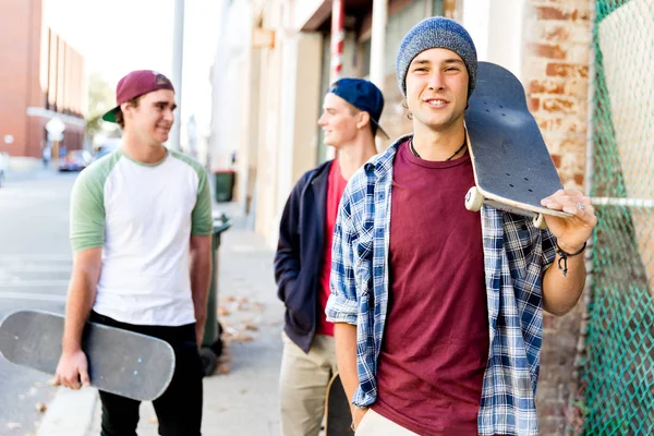 Adolescent garçon marche dans la rue avec son skateboard — Photo