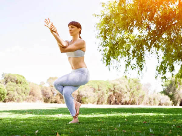 Genç kadın parkta yoga yapıyor. — Stok fotoğraf