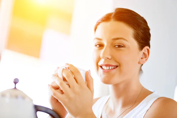 Mujer joven feliz con taza de té o café en casa —  Fotos de Stock