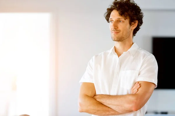 Portrait d'un jeune homme intelligent debout dans la cuisine — Photo