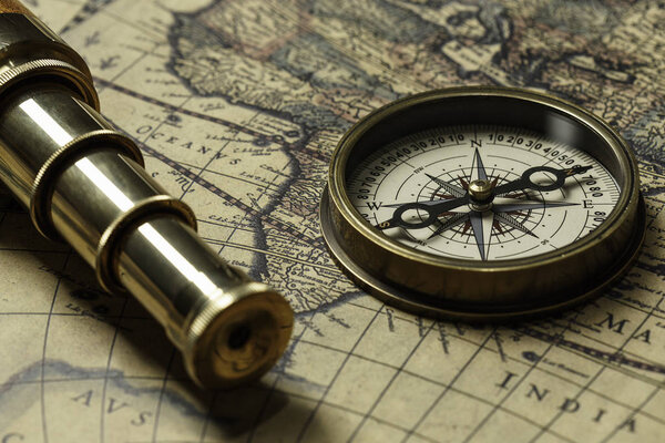 Retro compass with old map and spyglass