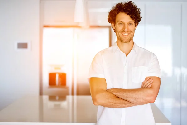 Portrait d'un jeune homme intelligent debout dans la cuisine — Photo