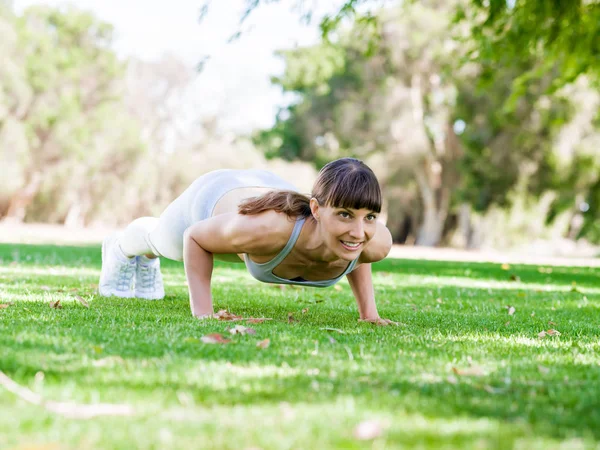 Młoda kobieta ćwicząca w parku — Zdjęcie stockowe