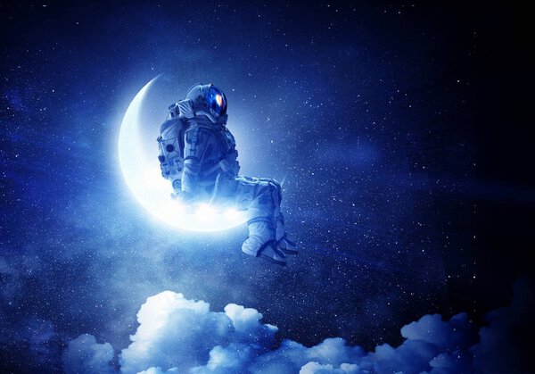 Spaceman sitting on moon against dark starry sky. Mixed media Elements of this image furnished by NASA
