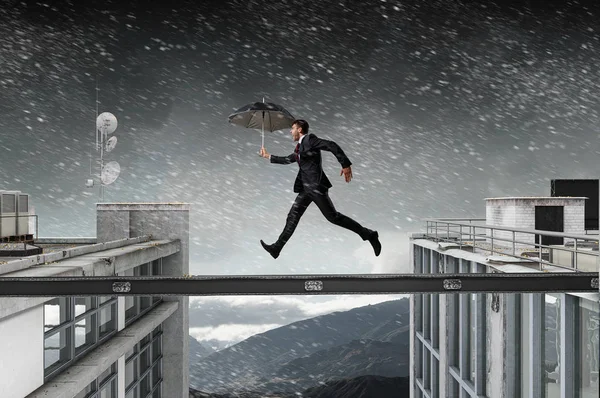 Fearless businessman overcoming difficulty. Mixed media — Stock Photo, Image