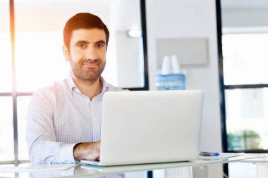 Bilgisayarda çalışan yakışıklı işadamı