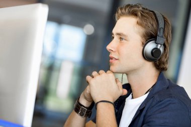 Kulaklıklar ile ofiste genç adam