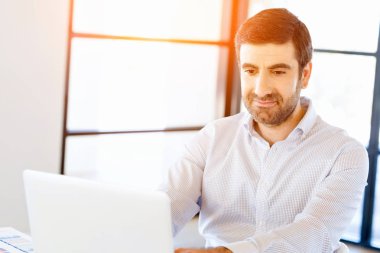 Bilgisayarda çalışan yakışıklı işadamı