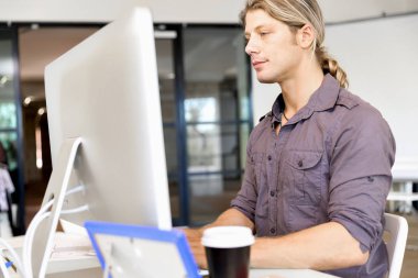 Bilgisayarda çalışan yakışıklı işadamı