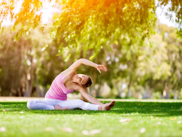 Mujer joven haciendo yoga en el parque — Foto de Stock