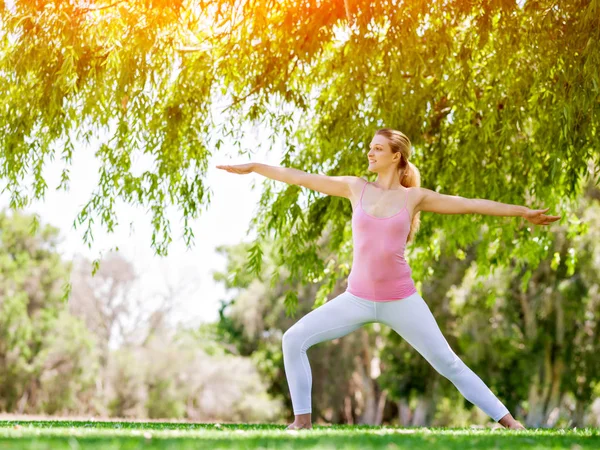 Giovane donna che fa yoga nel parco — Foto Stock